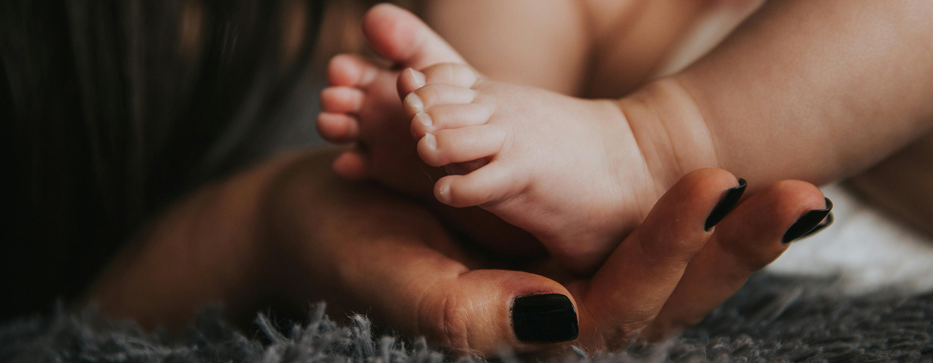 Pies de bebé y mano de mamá