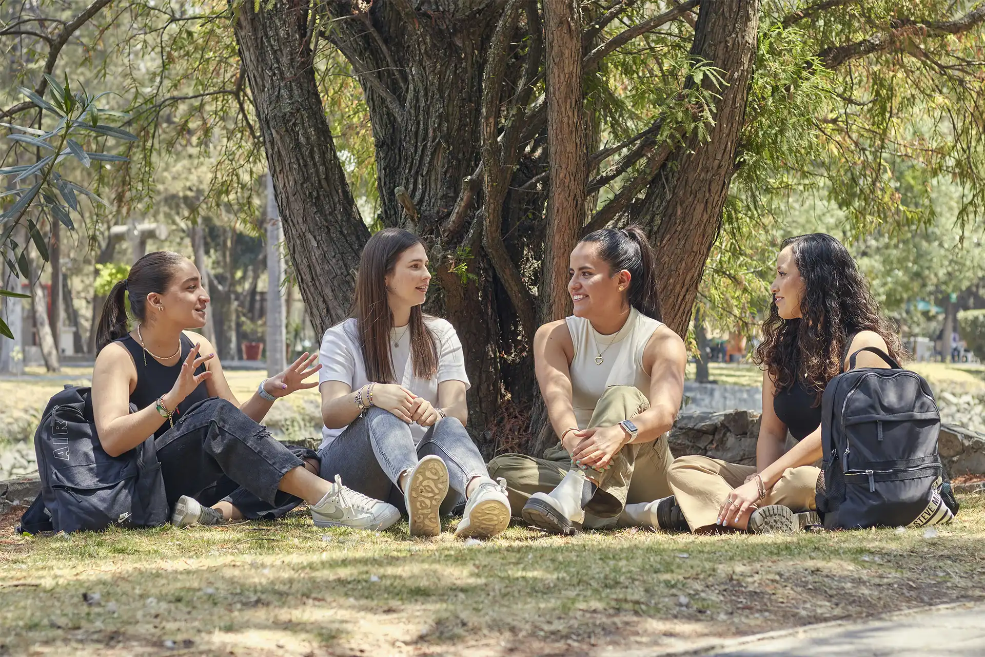 Cuatro estudiantes mujeres de la Licenciatura en Comercio Internacional platicando.