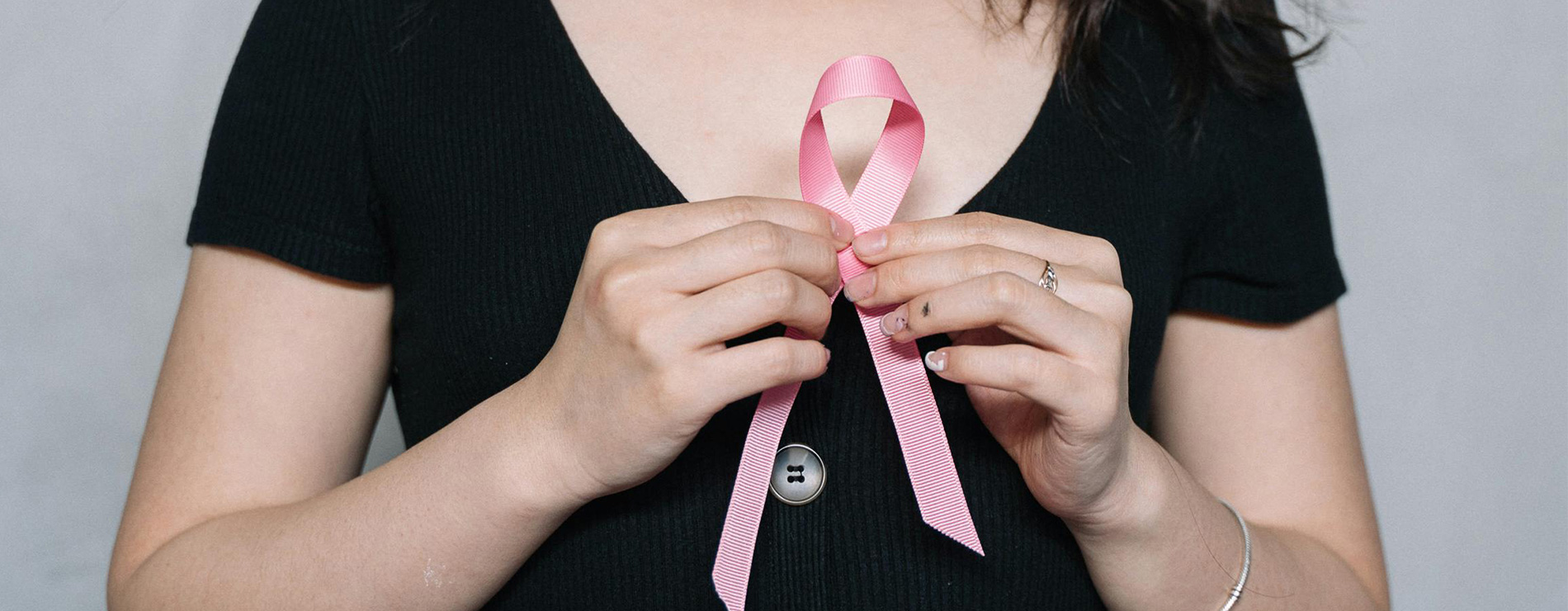 Mujer agarrando un moñito rosa